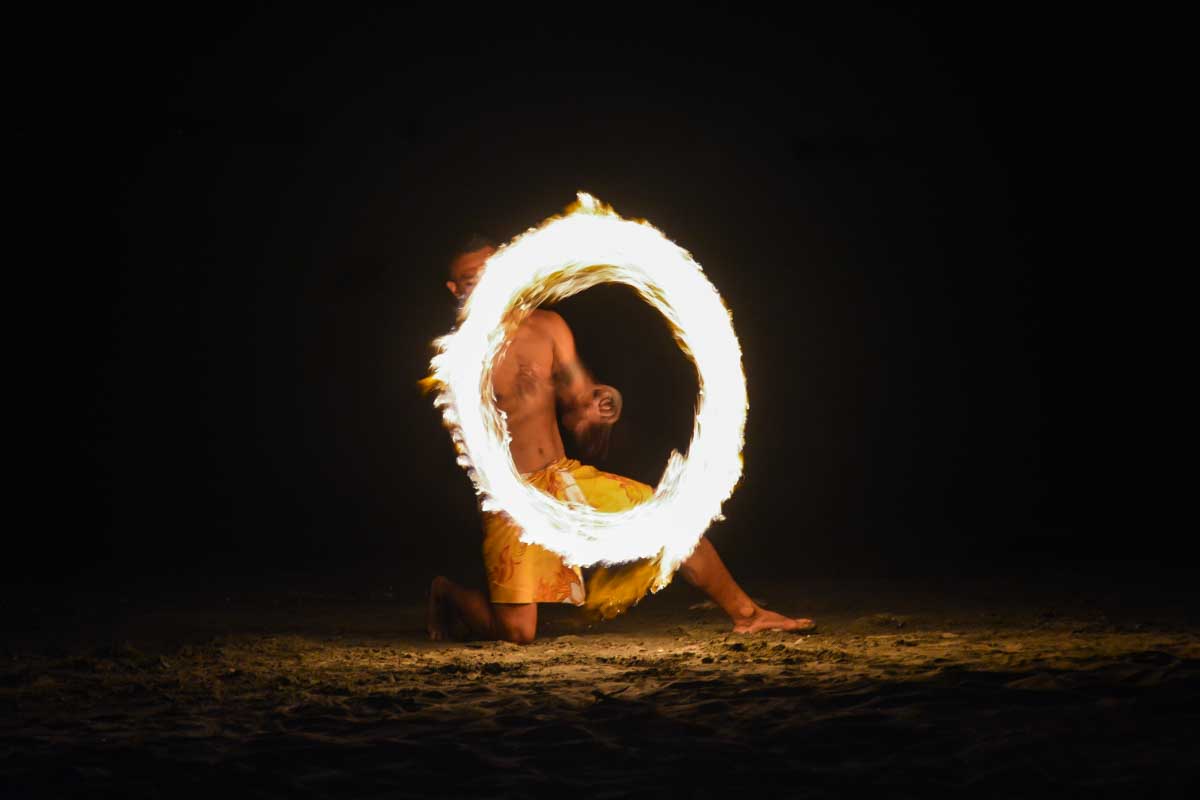A fijian man performs a fire dance at night at robinson crusoe island fiji