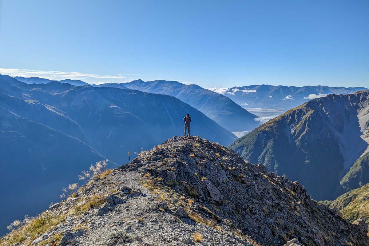 A lady stands on a viewpoint on Avalanche peak on Arthurs Pass, New Zealand
