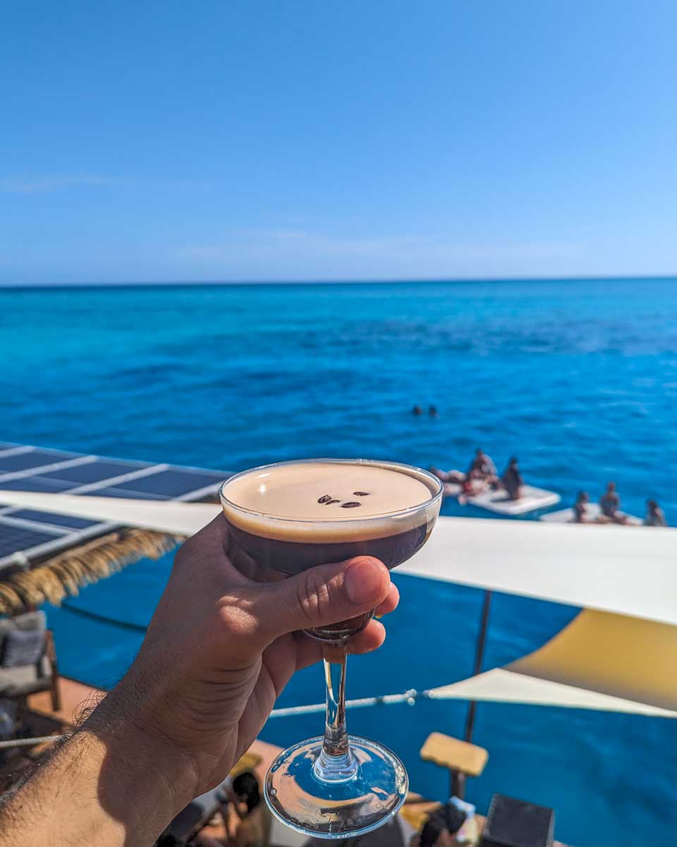 An expresso martini with views of the ocean on the Seventh Heaven Fiji Floating platform