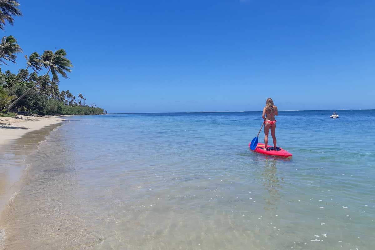 Bailey on a red stand up paddle board smiling on robinson crusoe island fiji
