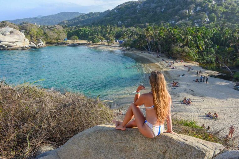 Bailey sits on a rock overlooking Cabo San Juan in Tayrona National Park