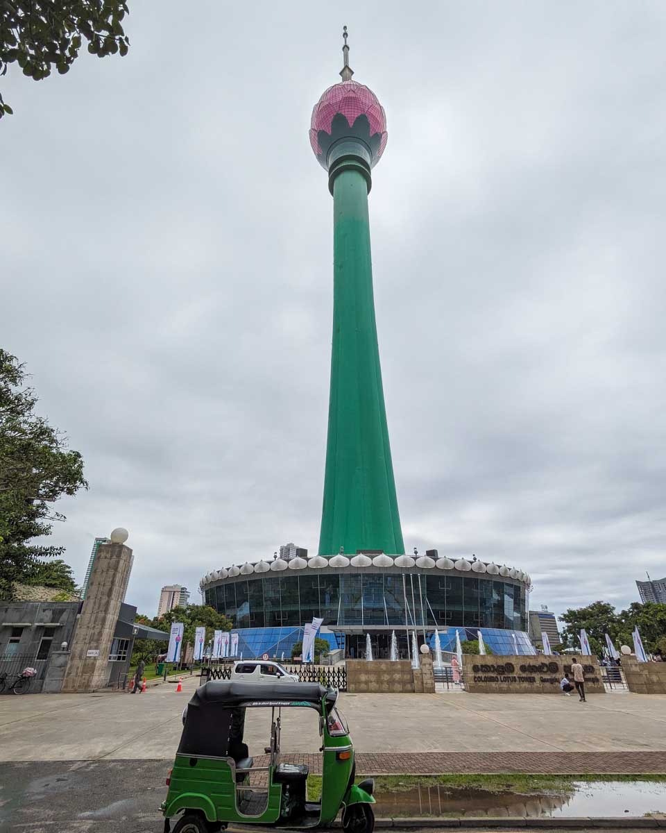 Looking at the lottus tower with a tuktuk in front of it Colombo Sri Lanka