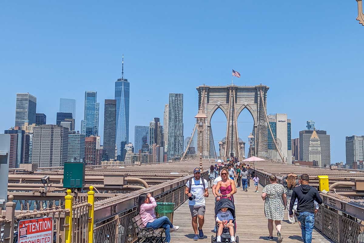 People walk along the Brooklyn Bridge in New York City