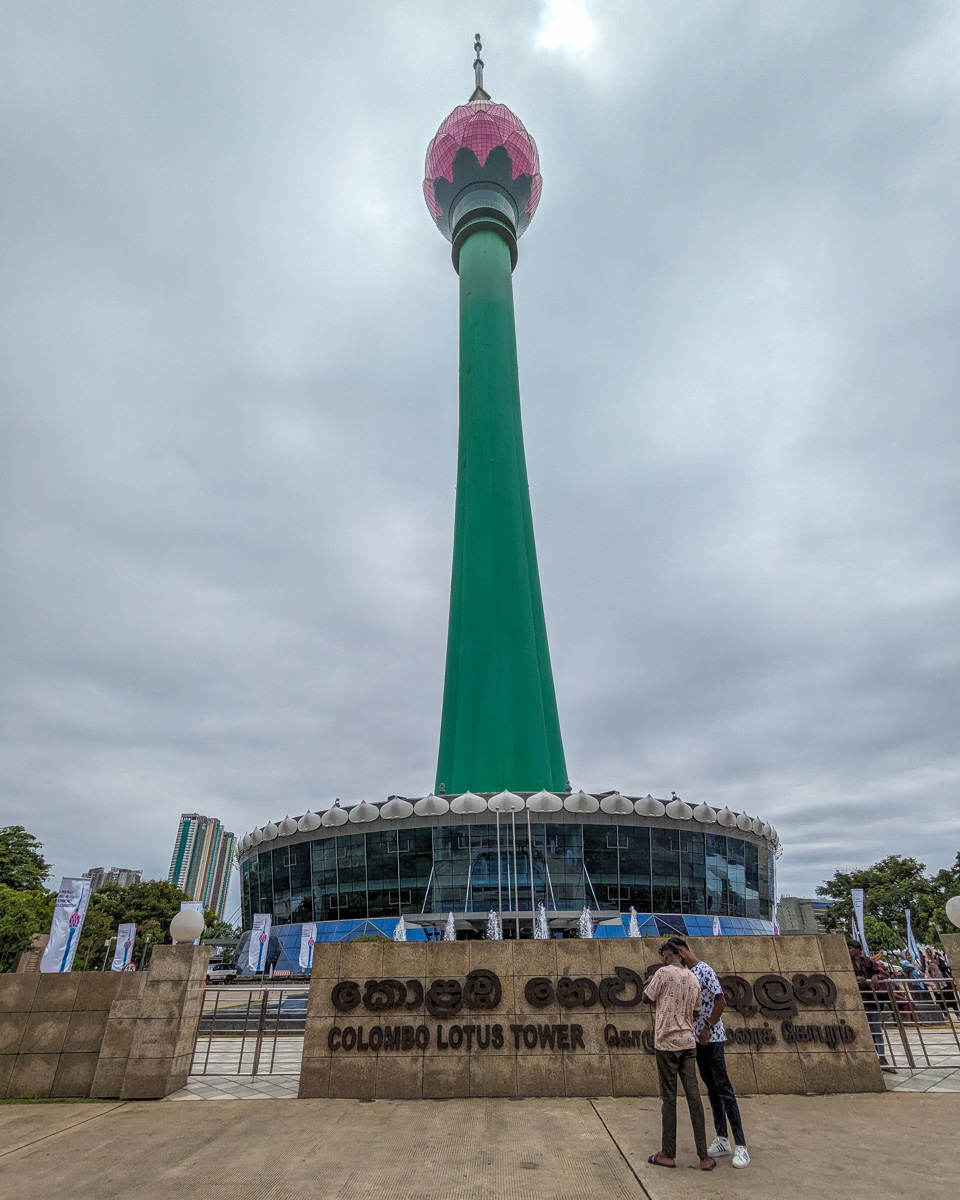 Standing at the base of the Lotus Tower while two men take pictures Colombo, Sri Lanka