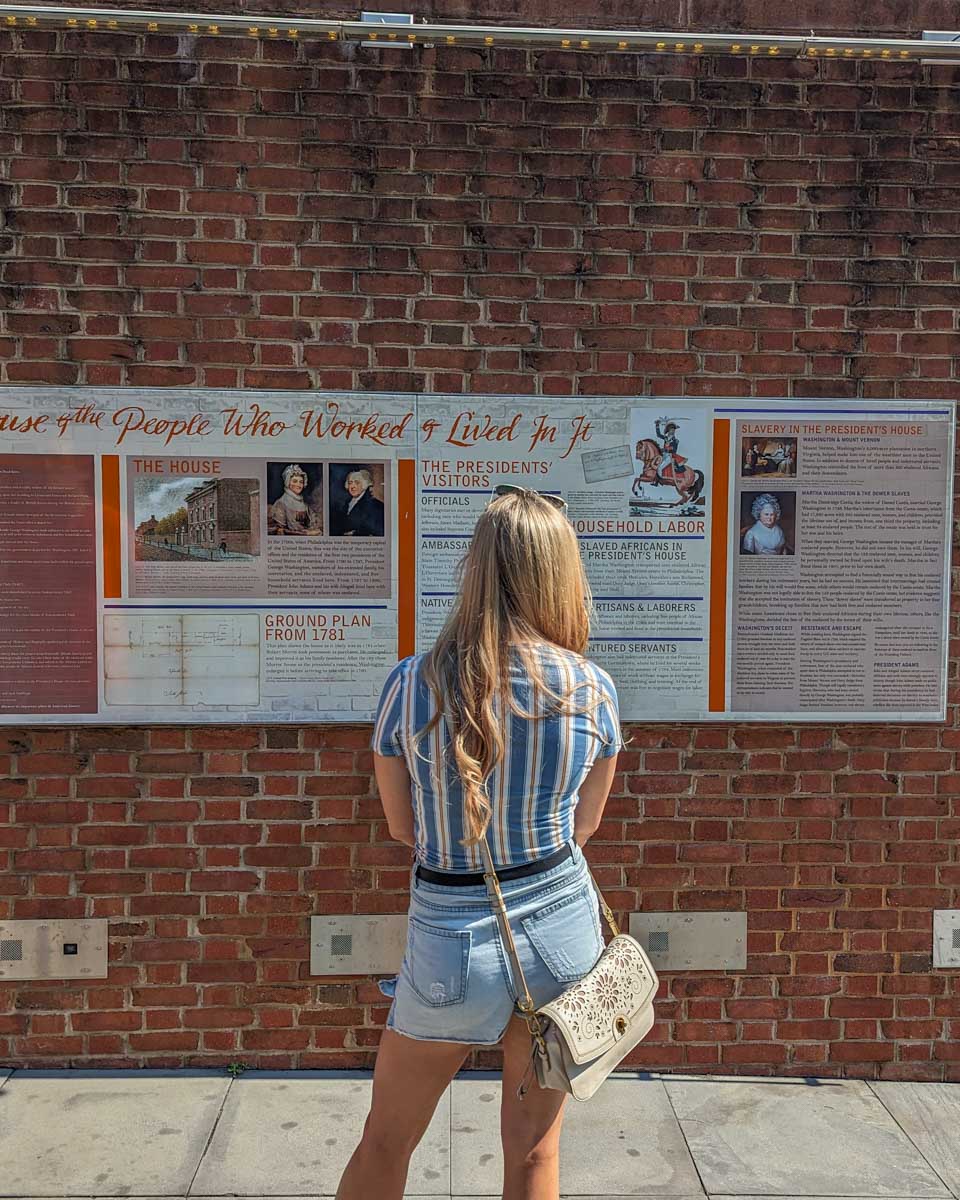 bailey reads a sign about Geroge Washingtons House in Philadelphia, USA