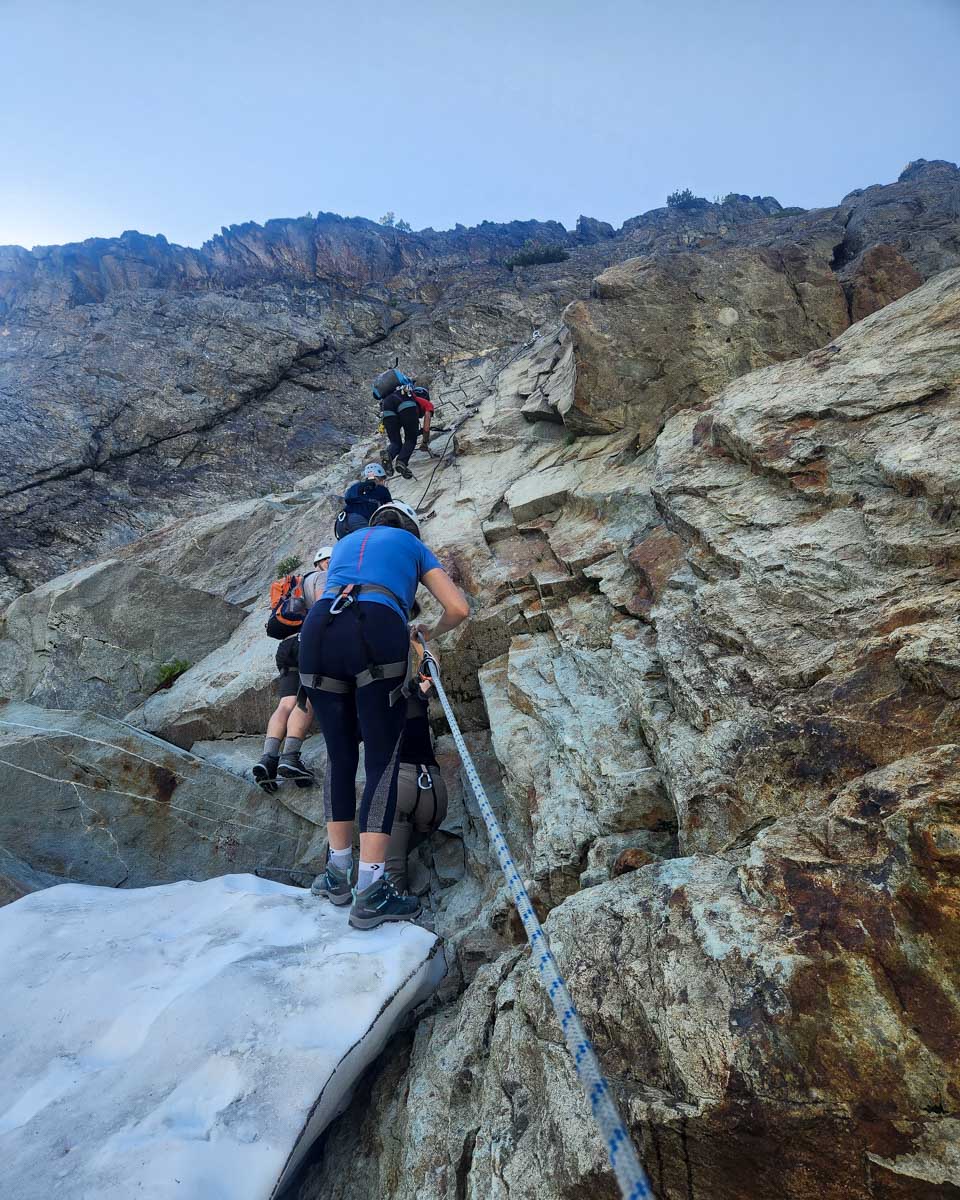 A shot of people climbing a steep cliff during Via Ferrata, Whistler, Canada