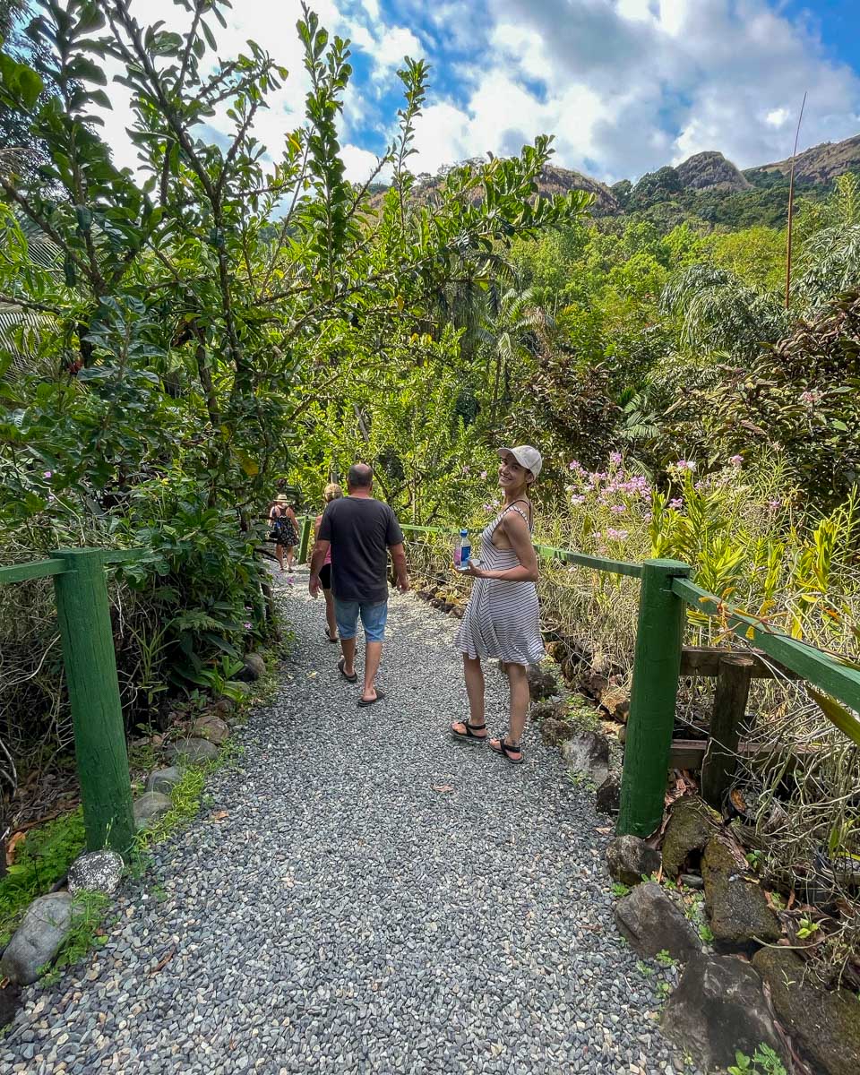 A woman smiles as she walks down a path at the garden of the sleeping giant fiji
