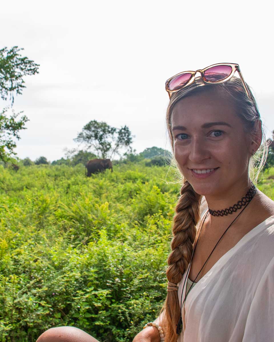 Bailey poses for a photo with an elephant in the background on Safari
