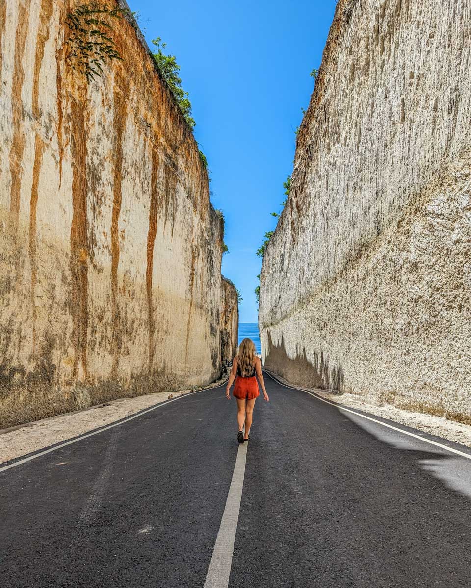 Bailey walks on the road below the Tanah Barak Cliff in Uluwatu, Bali