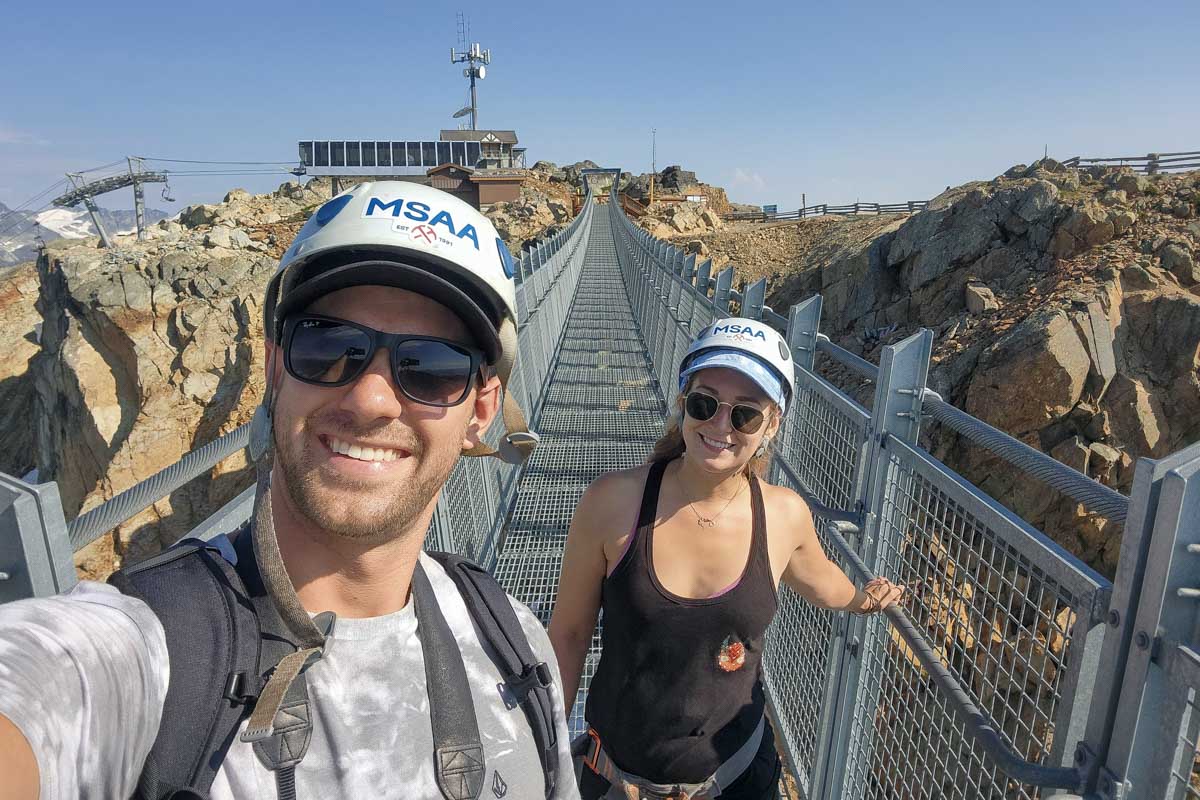 Daniel and Bailey smiling on the bridge to the ravens eye, whistler canada, during the via ferrata