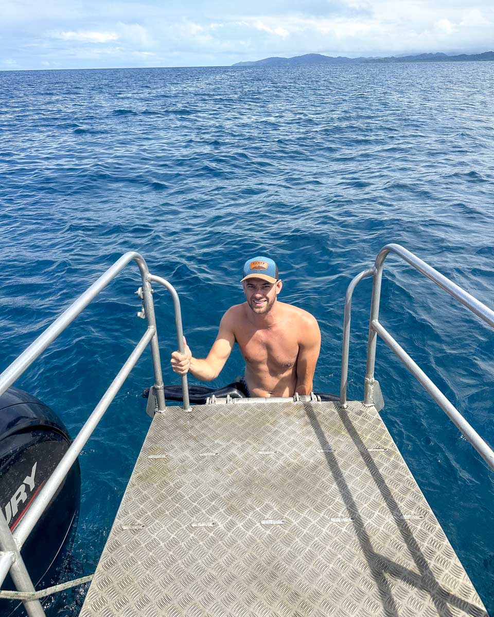 Daniel climbing out of the water during a shark dive fiji