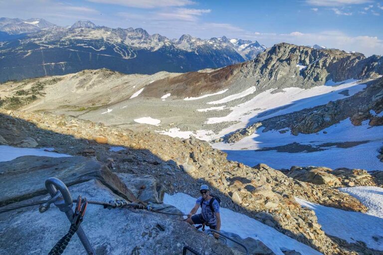 Daniel climbing up whistler hanging onto a rope during Via Ferrata, Whistler, Canada