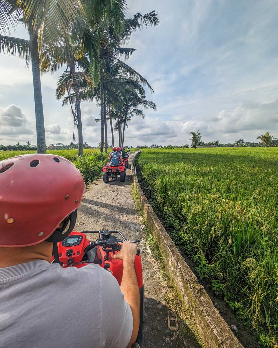Daniel rides an ATV through the rice fields of Bali on a tour