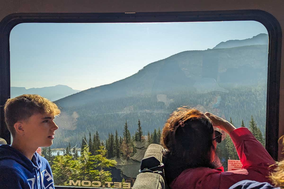People look out the window on the shuttle between Banff and Lake Louise