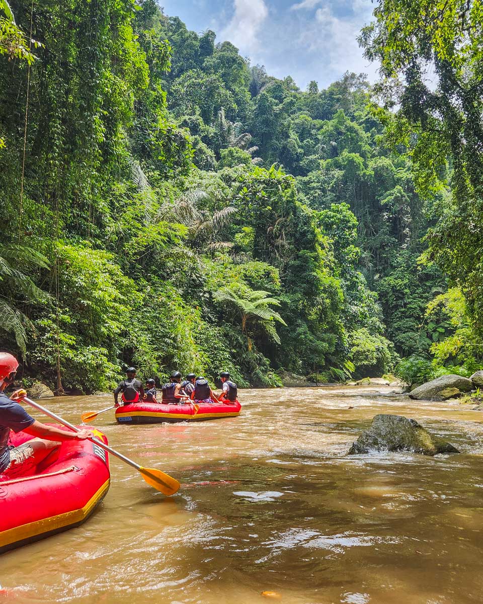 Rafts float down the river on a White water rafting tour in Bali