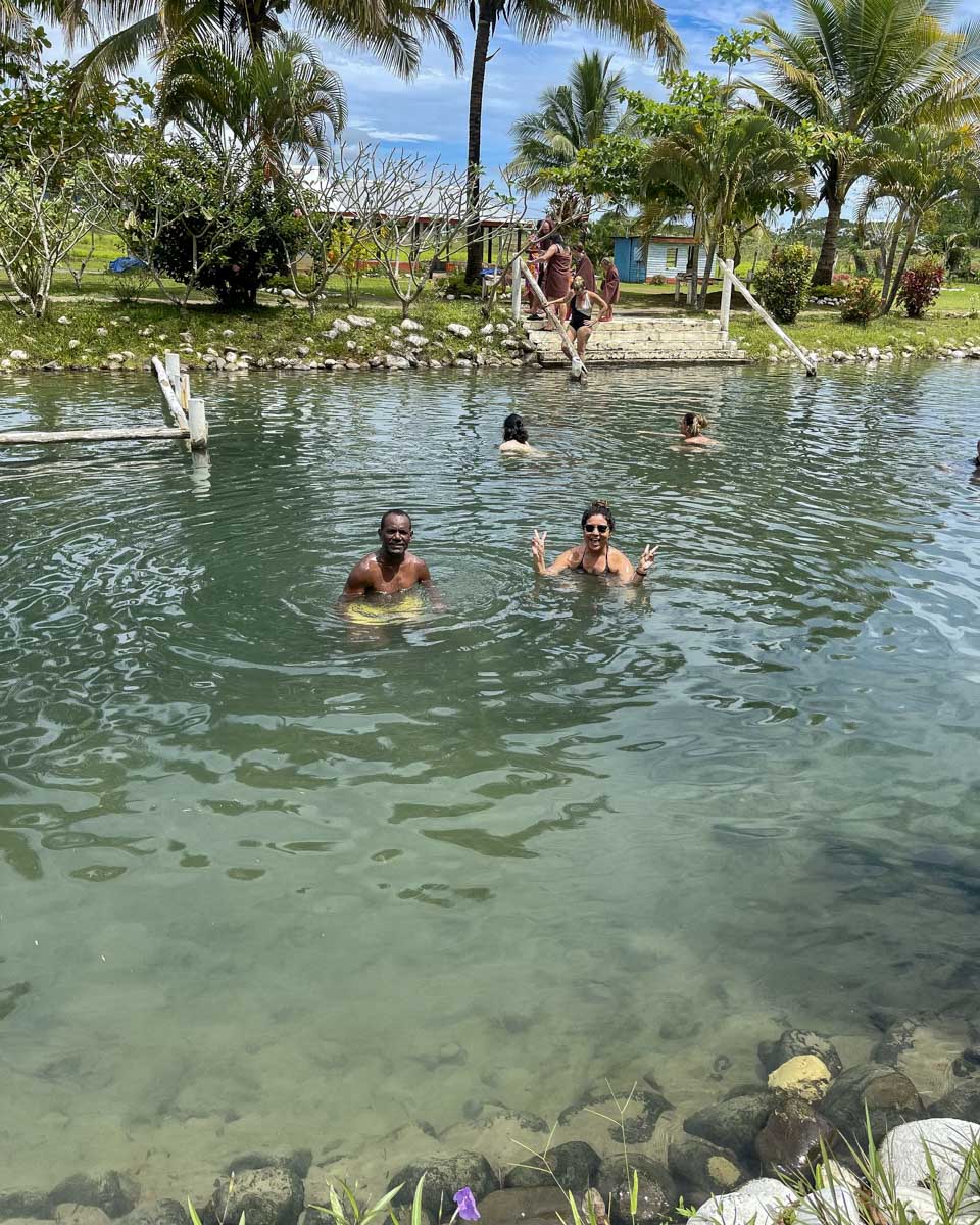 Two people in the hot spring mud pools at tifajek fiji