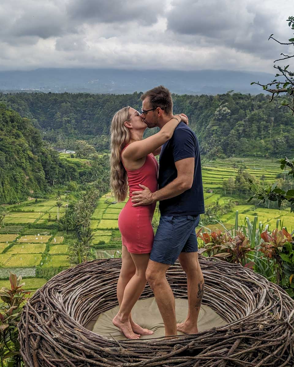 Bailey and Daniel kiss in a nest over a rice field on the instagram tour bali