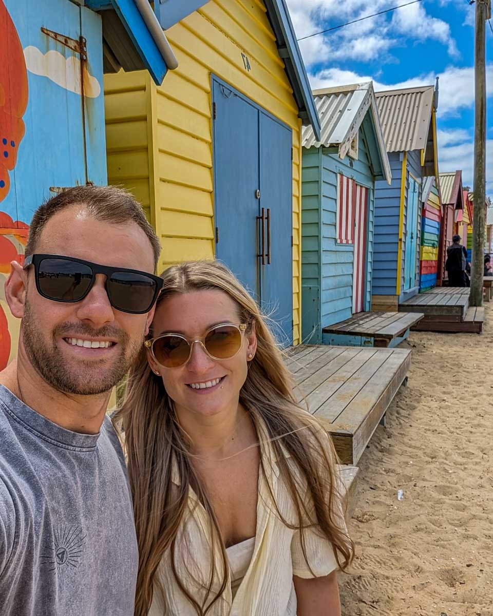Bailey and Daniel smile at the brighton bathing boxes on a go west penguin tour to phillip island