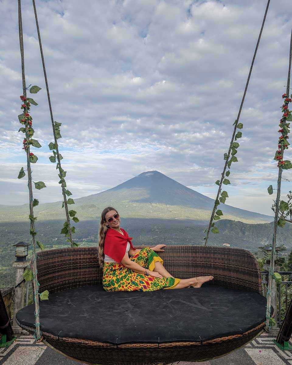 Bailey sits on a swing at Lempuyang temple during the Bali instagram tour