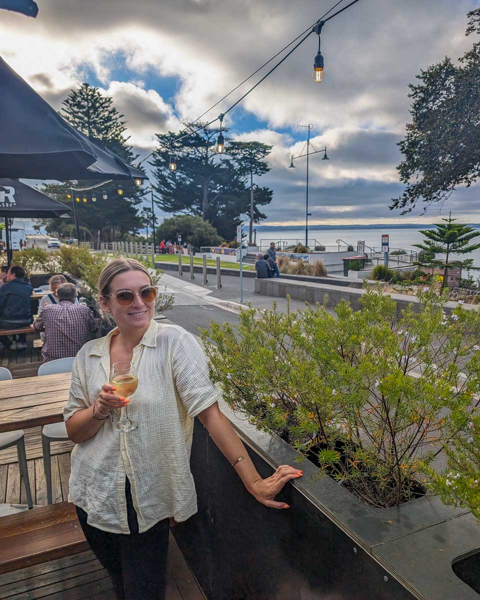 Bailey smiles with a glass of wine in the town of Cowes during a go west penguin tour to phillip island near melbourne australia