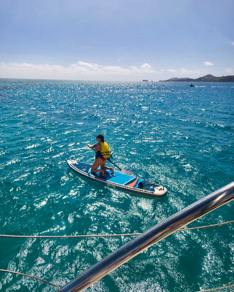 A woman enjoys a paddle board on a multi day cruise fiji