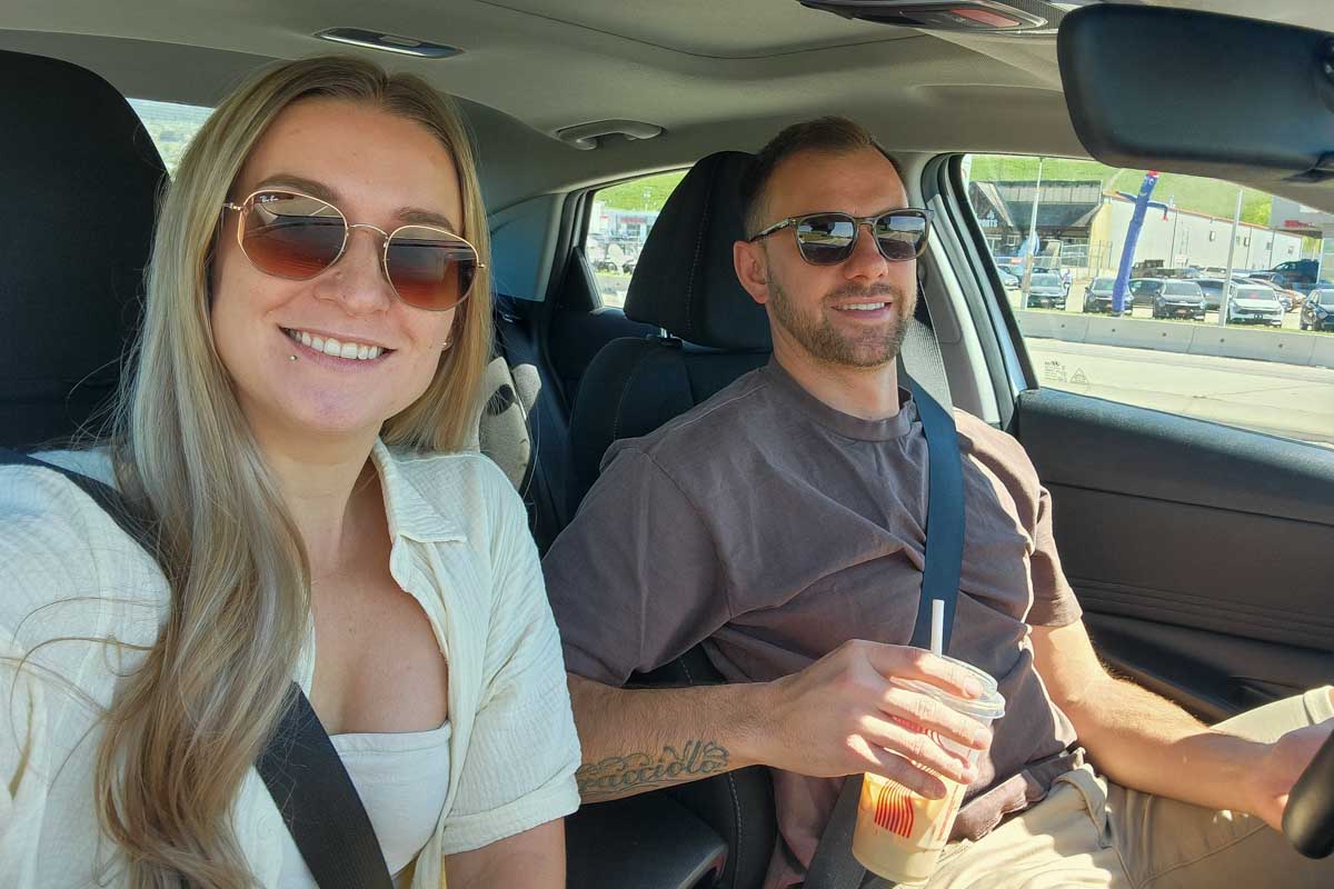 Bailey and Daniel smile in their rental car Kelowna Canada