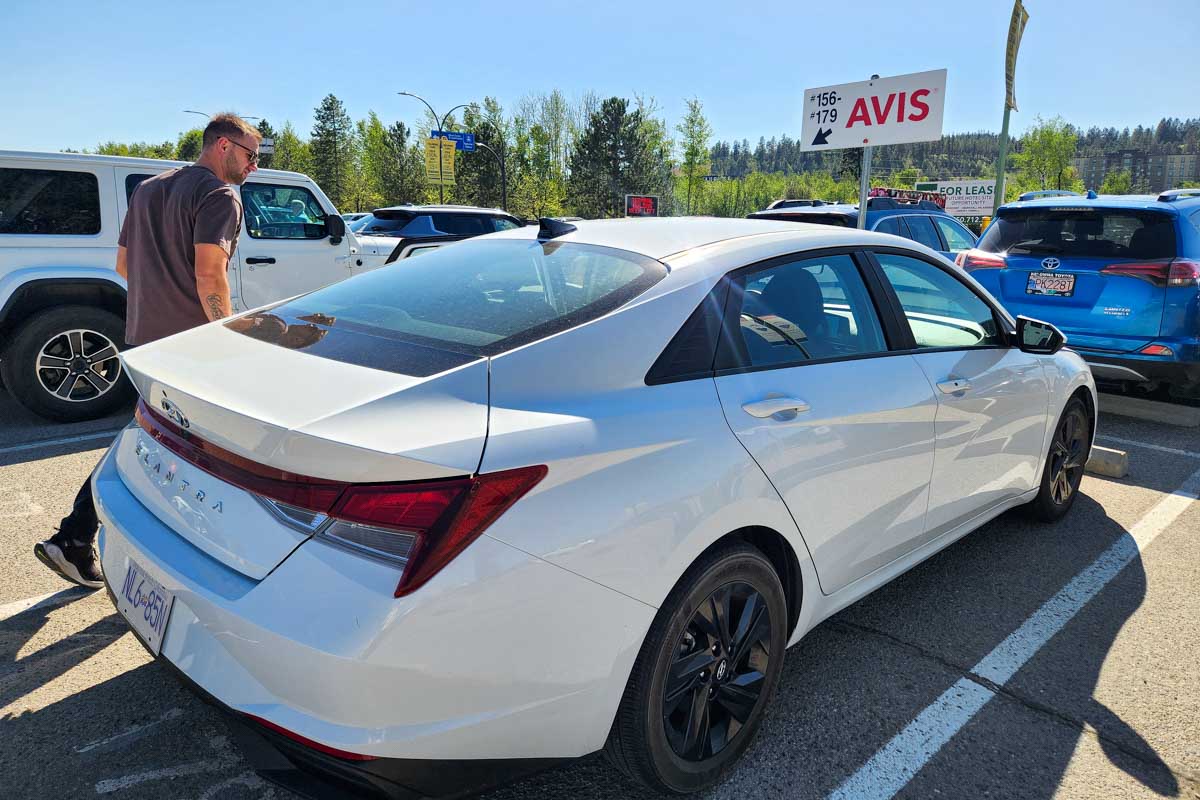 Daniel walks up to their rental car in Kelowna Canada