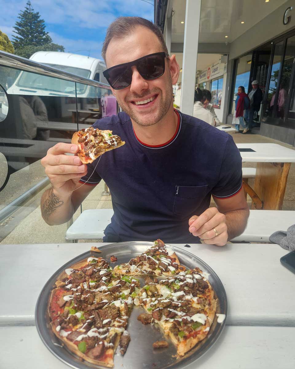 Daniel eats pizza in Apollo Bay on the Great Ocean Road