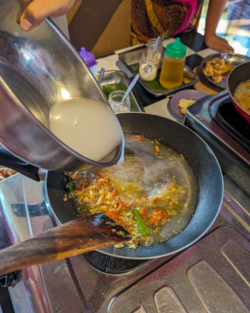 A person cooks with a pan during a cooking class in Ubud Bali