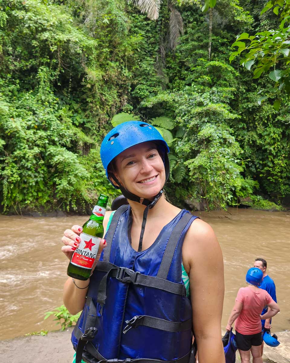 Bailey holding a beer on a rafting trip in Bali