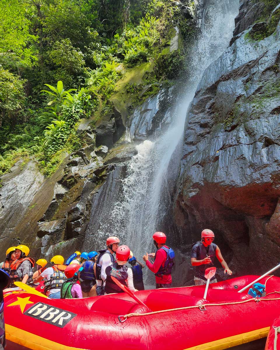 People raft by a waterfall in Bali