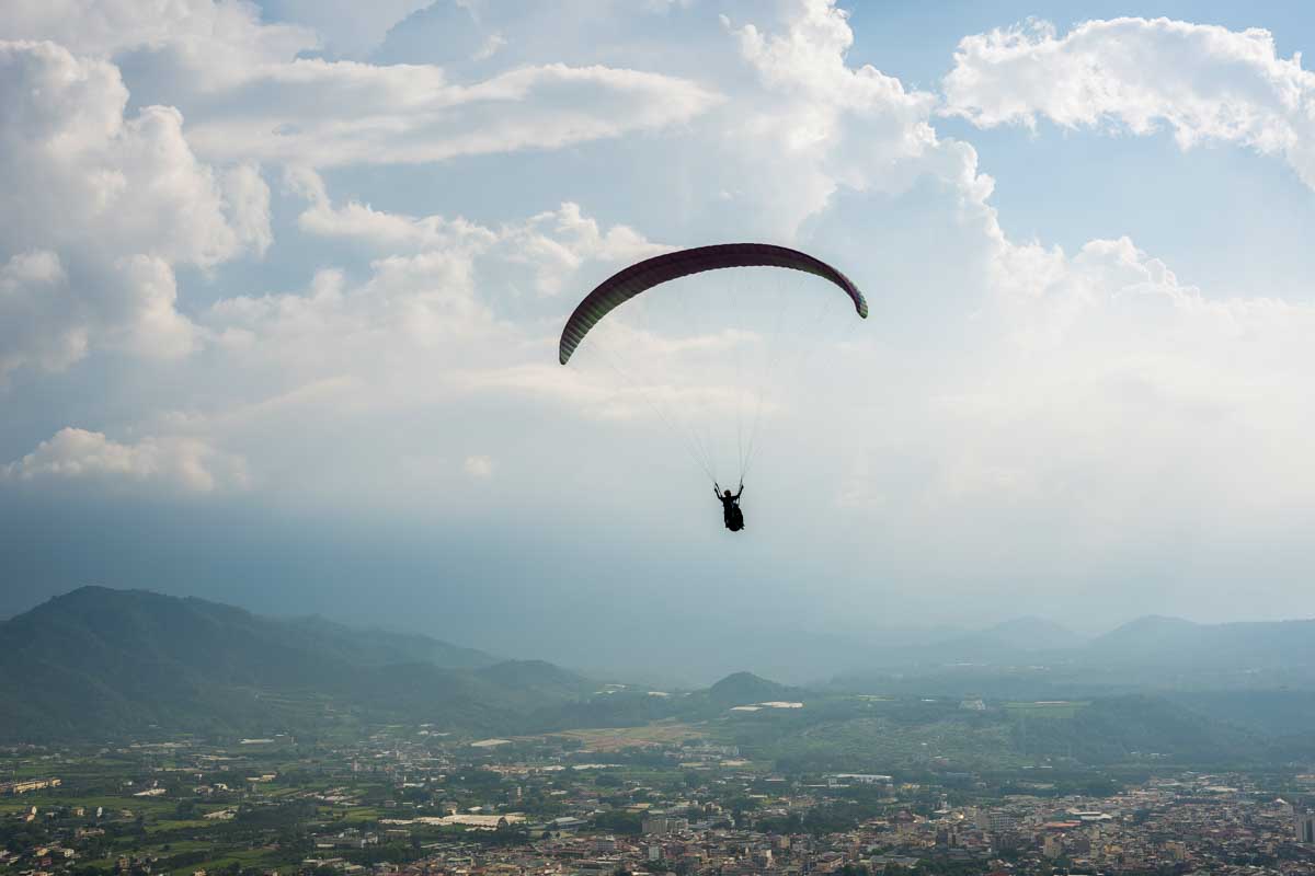 Person paragliding in sky over Medellin Colombia