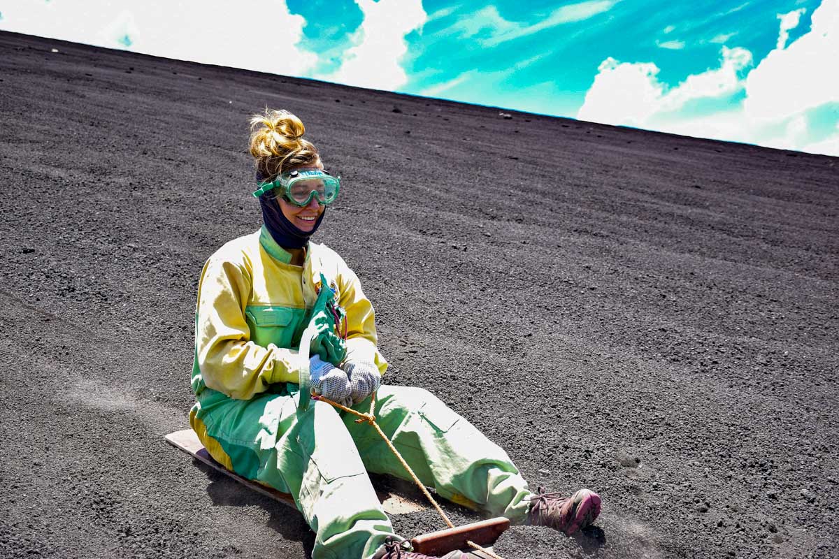 Bailey holds on while volcano boarding down cerro negro in Nicaragua