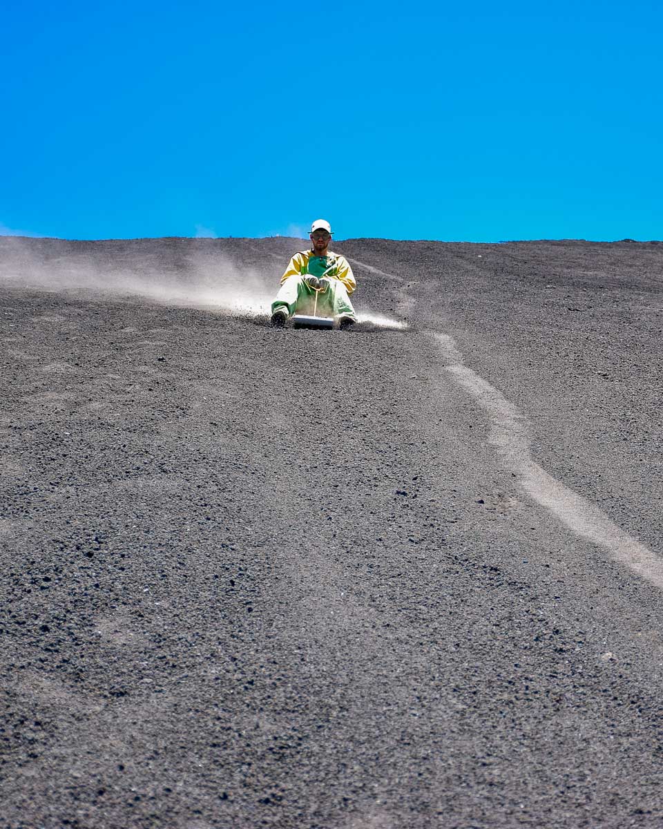 Daniel goes fast down the cerro negro volcano boarding slope in Nicaragua