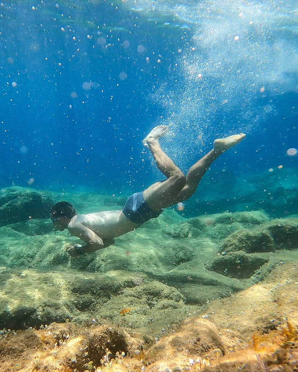 A person dives under the water in Costa Brava Span