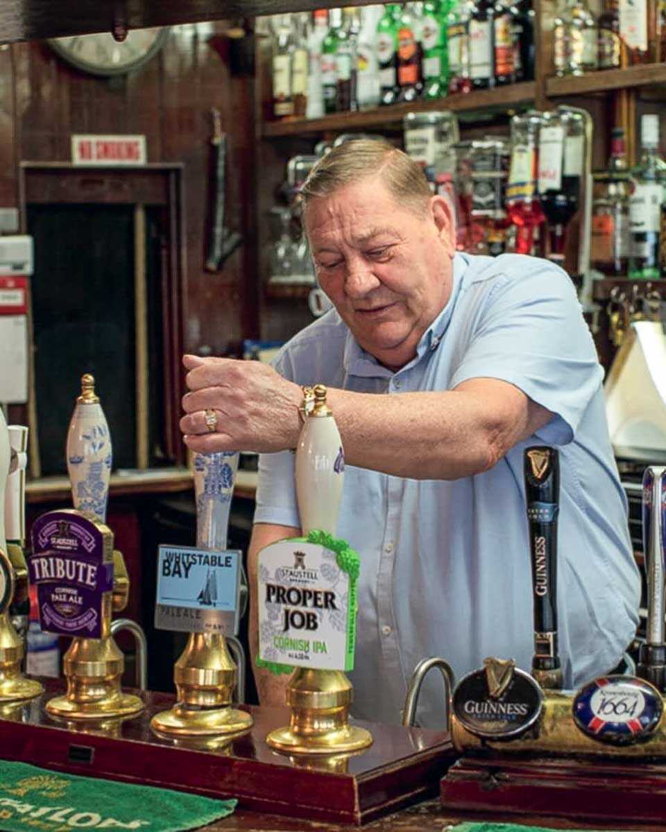 Liquid History Tours man pours beer in a pub London England