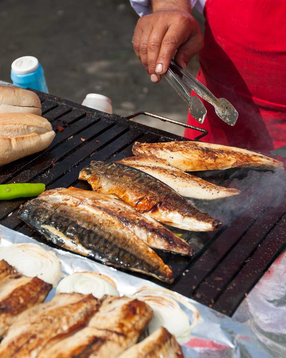 A man grills fish in a market on a food tour in Istanbul, Turkey