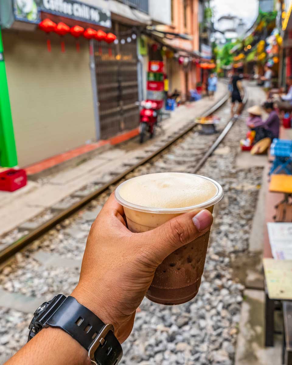 A person drinks coffee on train street in Hanoi Vietnam