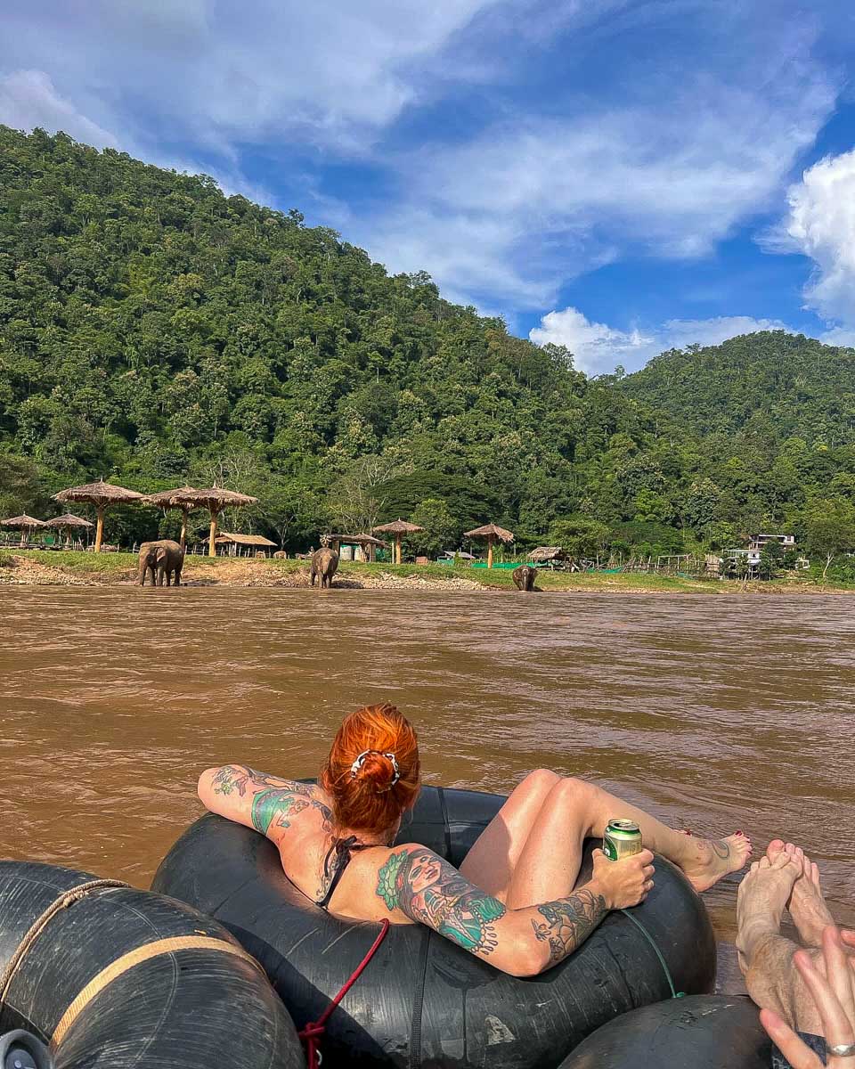 tubingchiangmai a person floats down the river with elephants near by on a tour from Chiang Mai Thailand