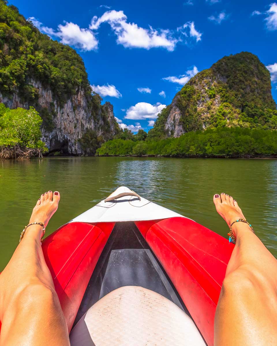 A person kayaks by cliffs on a tour from Krabi Thailand