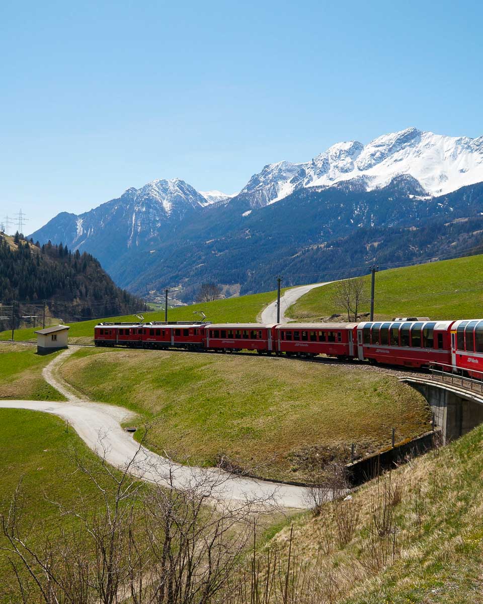 Bernina Express Red Train heading through the Swiss Alps on a tour from Milan Italy