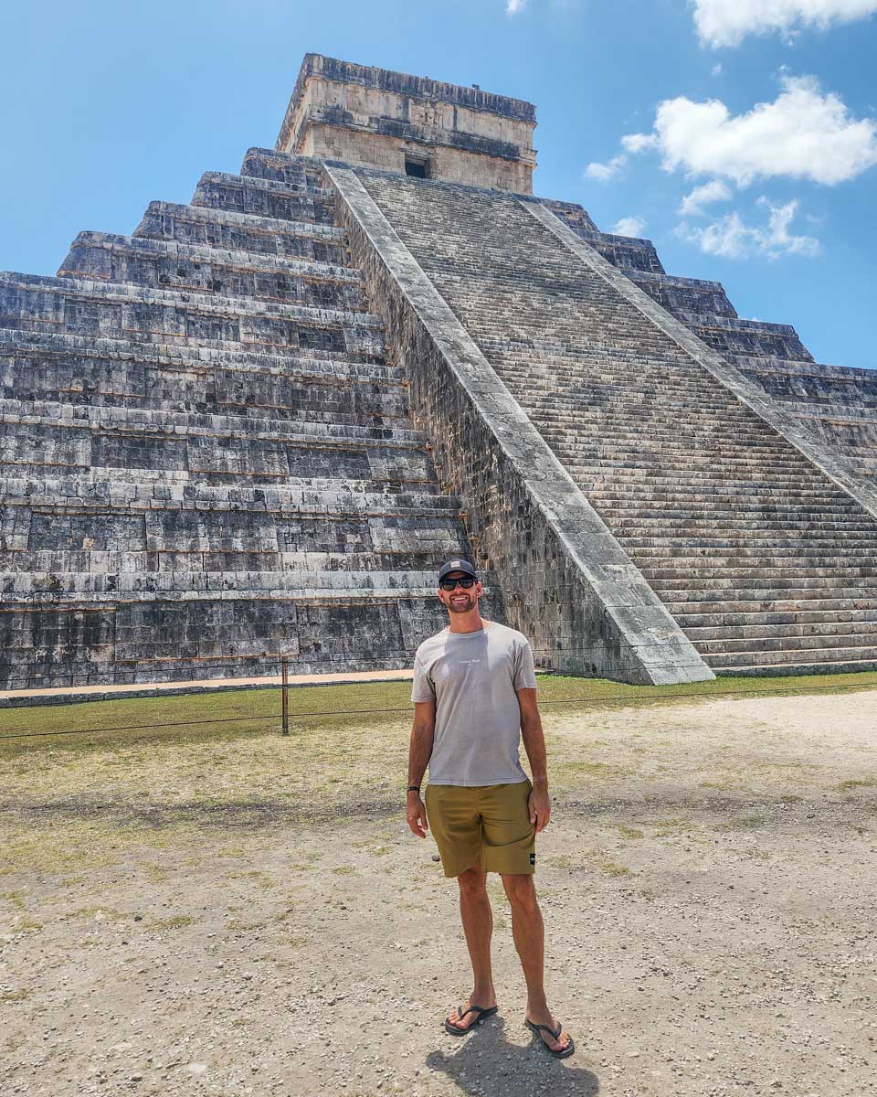 Daniel-poses-for-a-photo-with-the-main-pyramid-at-El-Castillo-Chichen-Itza on a tour from Merida Mexico
