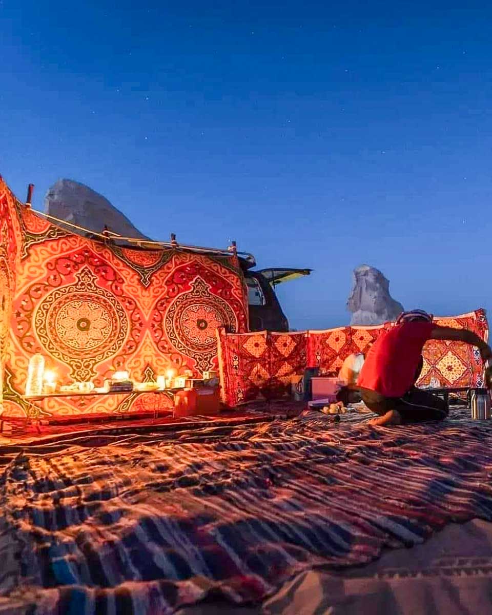 Egypt White Desert Tours a man sets up a tent in the white desert on a camping trip from Cairo Egypt