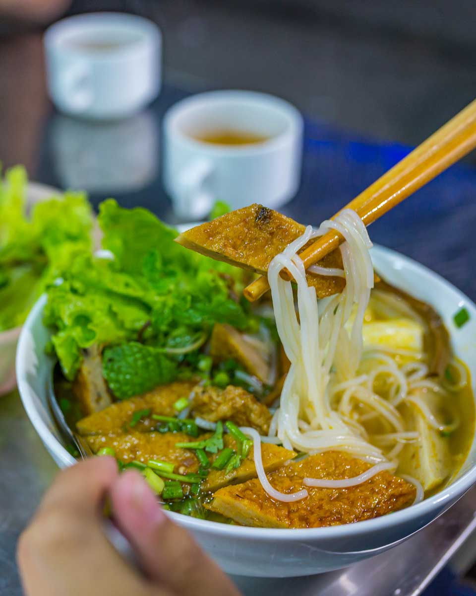 A person eats soup on a food tour in Hoi An Vietnam
