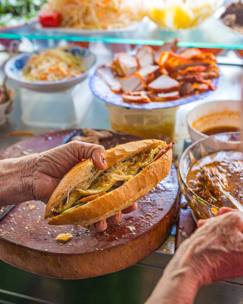 A person makes Banh Mi during a food tour in Hoi An Vietnam