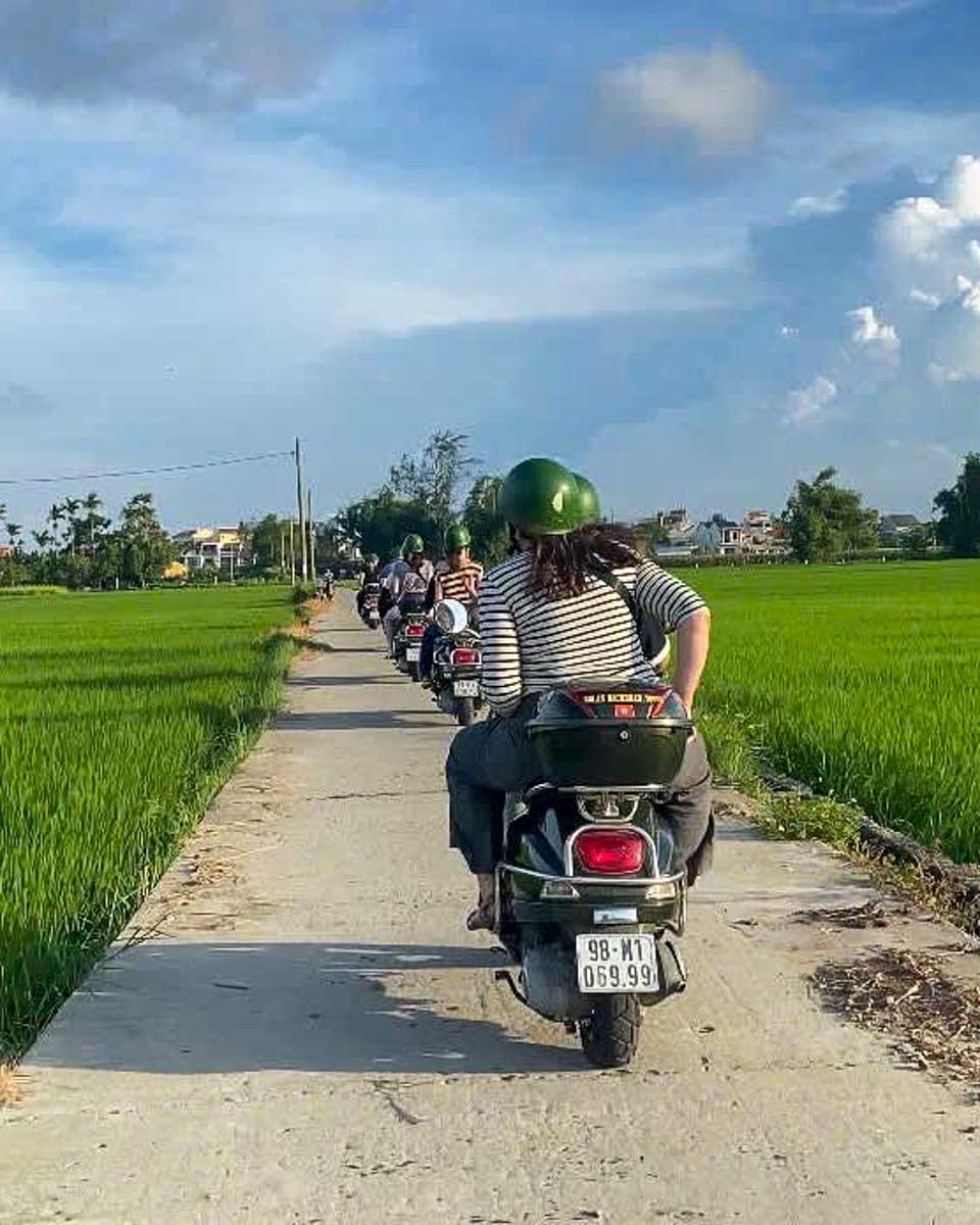 Amber Journeys people ride vespas through the countryside on a tour from Hoi An Vietnam