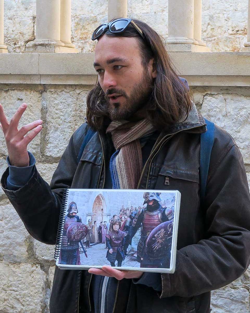 Dubrovnik Walking Tours a guide holds images from Game of Thrones while on a tour in Dubrovnik Croatia
