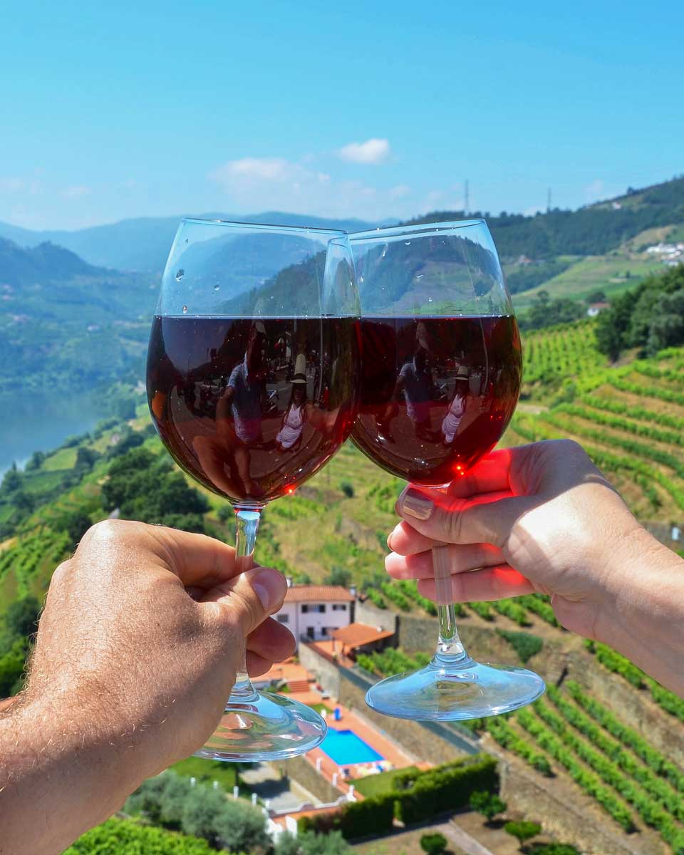 Two people drink wine in the Douro Valley on a tour from Porto Portugal
