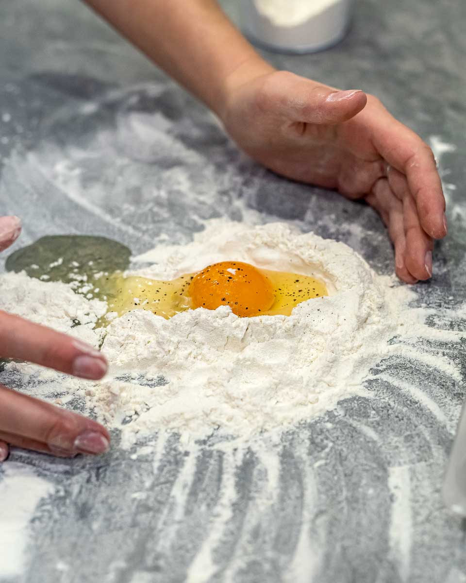 A person making noodles during a pasta making cooking class in Florence Italy