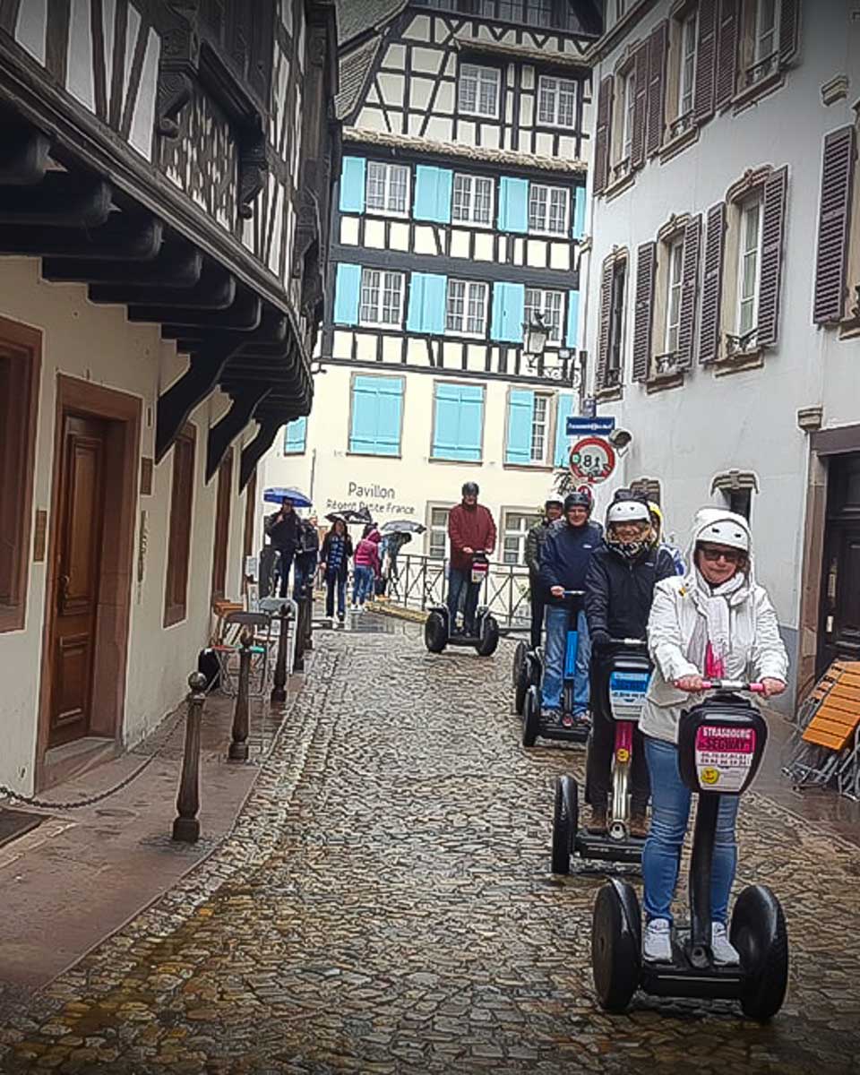People segway along cobblestone streets on a tour in Strasbourg France